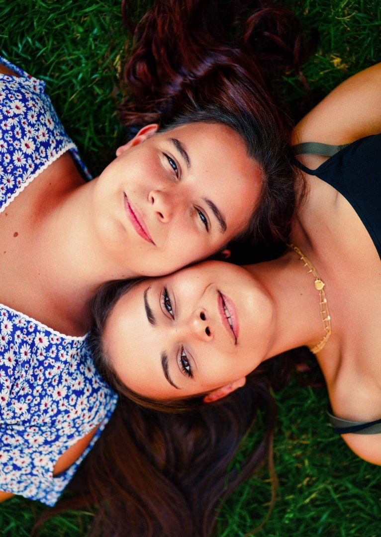 Deux femmes allongées dans l’herbe, souriantes
